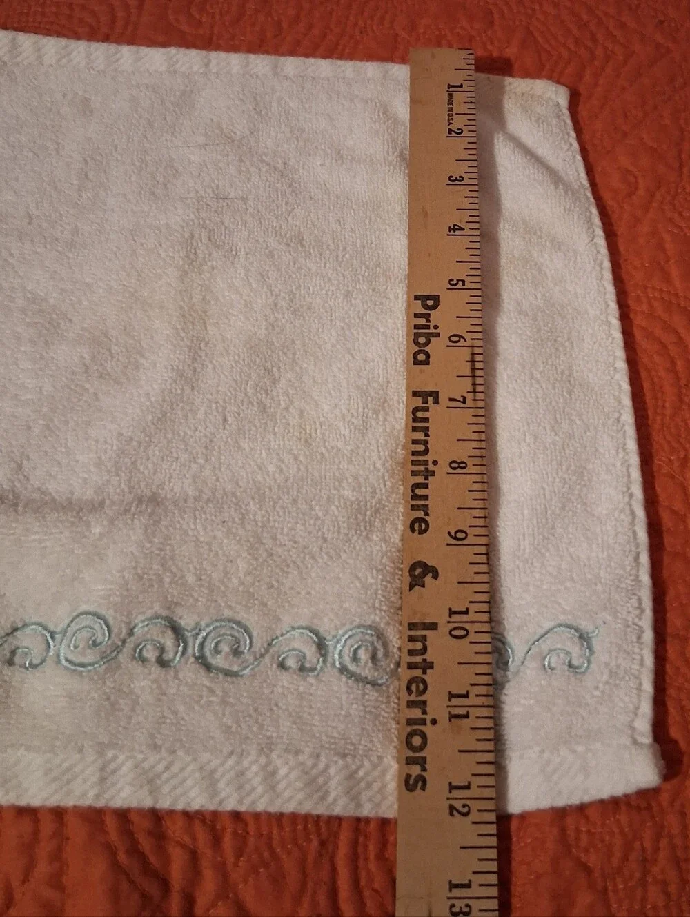 Hand Towel And Wash Cloth With Teal Design On It